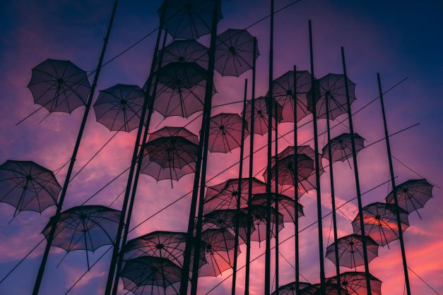 Viele Regenschirme vor blau-rosa Himmel. Hotwire, Web3, Metaverse, Umbrella Tokens